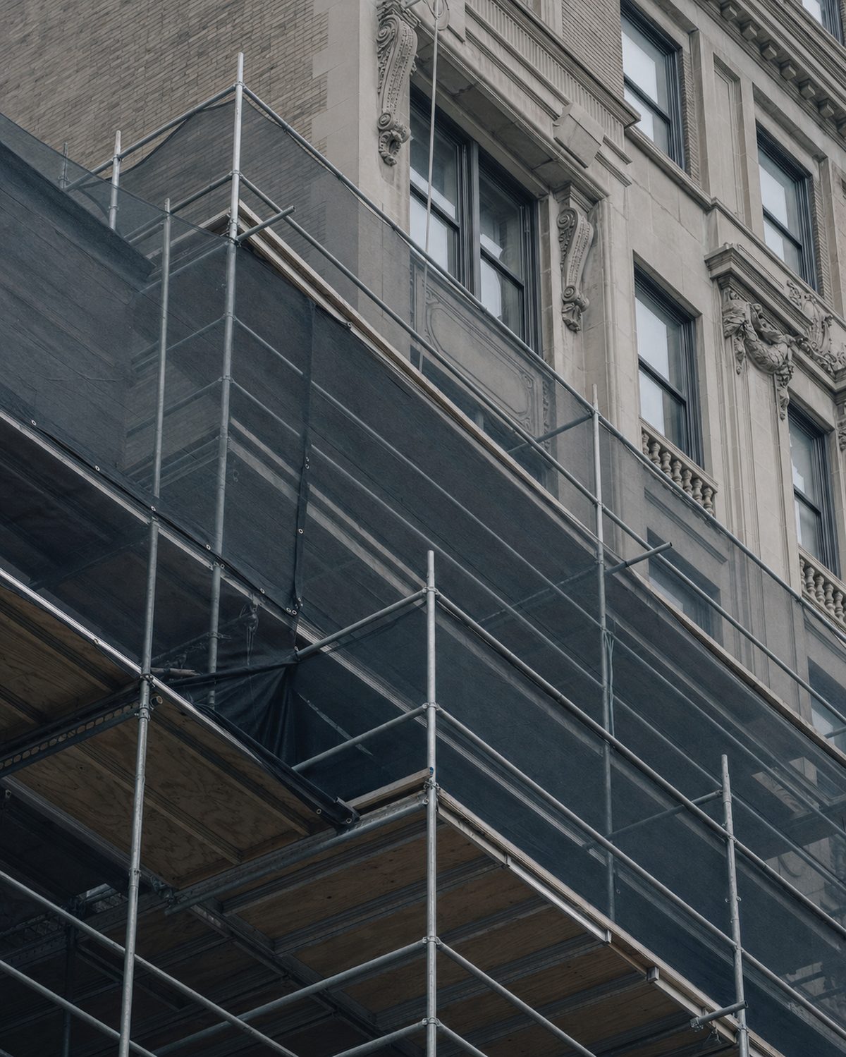 Scaffolding and sidewalk shed against a pre-war New York City building facade
